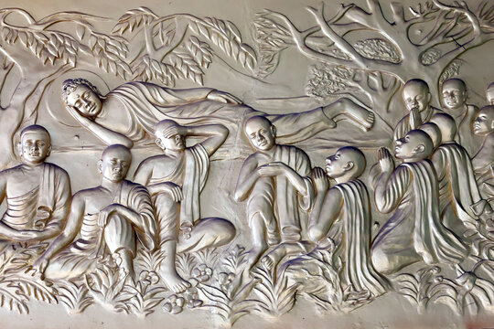 Xa Loi Pagoda. This bas-relief depicts Buddha Siddhartha Gautama in the parinirvana posture, surrounded by his disciples in prayer and meditation. Ho Chi Minh City, Vietnam.