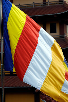 Vietnam Quoc Tu Pagoda. The Buddhist flag, a symbol of peace and harmony, flies in front of a temple. Ho Chi Minh City, Vietnam.