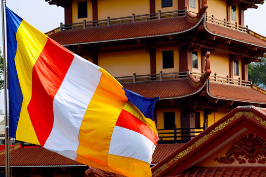 Vietnam Quoc Tu Pagoda. The brightly colored Buddhist flag flutters in front of a traditional temple. Ho Chi Minh City, Vietnam.