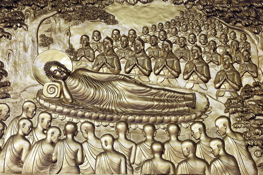 Vietnam Quoc Tu Pagoda. A relief sculpture depicting the Buddha in the parinirvana posture, surrounded by his disciples and worshippers in prayer,. Ho Chi Minh City, Vietnam.