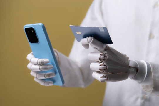 Robot Hand Holding Credit Card and Smartphone for Online Shopping and AI Payment Concept
