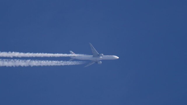 Real Passenger Jet with Contrails Flying Left to Right Slow Motion Tracking Shot
