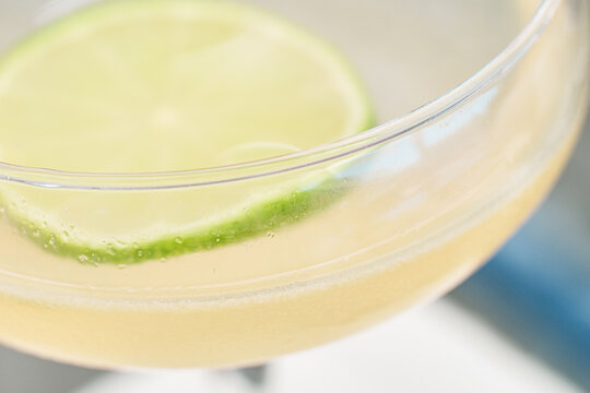 Close-up of a refreshing alcoholic cocktail in a glass garnished with fresh lime slice