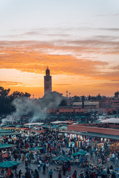 Locals and tourists visit the vibrant Jemaa el Fna night market beneath the Koutoubia Mosque
