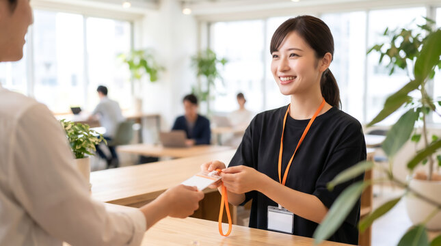 コワーキングスペースの受付で笑顔で接客や案内をする女性スタッフ