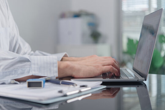 hands typing laptop keyboard working office desk stamp document clipboard foreground businessman processing digital data internet communication administration online corporate workspace technology