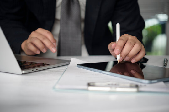 businessman hands using stylus digital tablet signing electronic contract agreement corporate office desk working laptop finance management legal paperwork professional executive technology screen