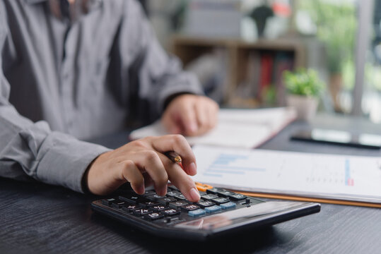 hands using calculator desk accounting finance calculating budget taxes business working financial documents charts pen planning investment auditing paperwork money cost bookkeeping market economy