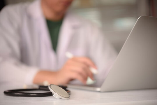 clinic desk stethoscope focus blurred physician working laptop background medical professional healthcare consultation digital health online telemedicine treatment diagnostic hospital environment