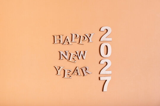 Happy New Year 2027 message made with wooden letters on a plain background