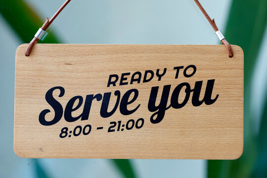 A wooden sign reads "Ready to serve you" along with the hours of operation, 8:00 a.m. to 9:00 p.m., suggesting that service is available. Ho Chi Minh City, Vietnam.