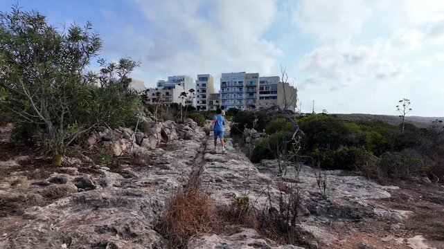 Children discovering ancient Cart Ruts on Xemxija heritage trail, Malta.