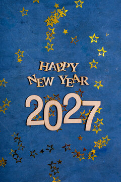 Happy New Year 2027 text with gold stars and blue background