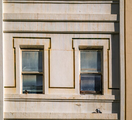 Obraz premium Old Wooden Windows on a Creme Toned Building with Yellow Facade.