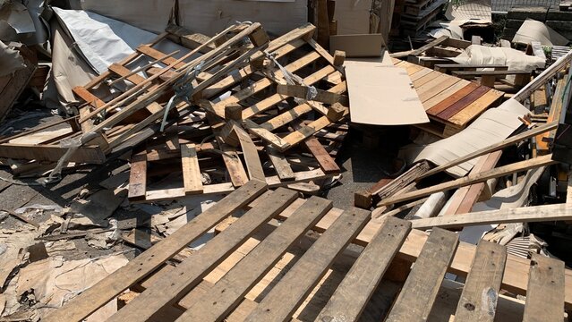 Pile of discarded wooden pallets and construction debris collected for waste disposal or recycling