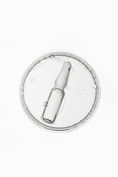 Glass medical ampoule in transparent liquid with air bubbles, laboratory research concept
