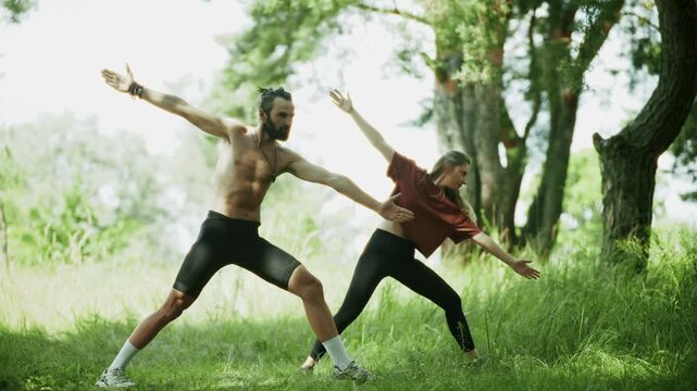 Yogis Practicing Warrior Pose In  Park. Training Nature. Meditation And Balance. Healthy Lifestyle