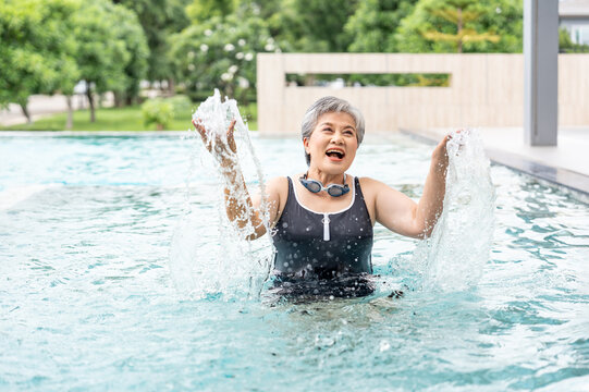 portrait happy elderly man in swimwear and goggles enjoying exercising in swimming pool,elderly lifestyle,health care,aquatic exercise,wellness,wellbeing