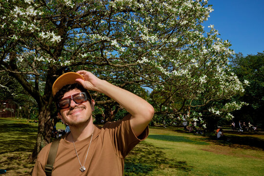 Man Smiling Under Flowering Tree in Tokyo Park