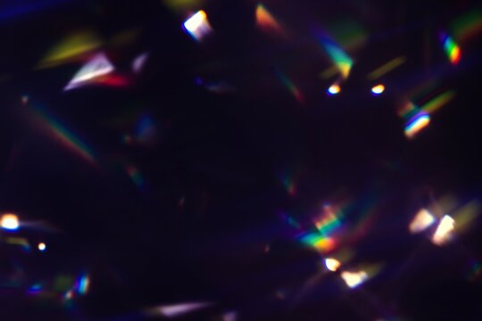 Blur colorful rainbow crystal light leaks on black background. Defocused abstract multicolored retro film lens flare bokeh analog photo overlay or screen filter effect. Glow Vintage prism colors
