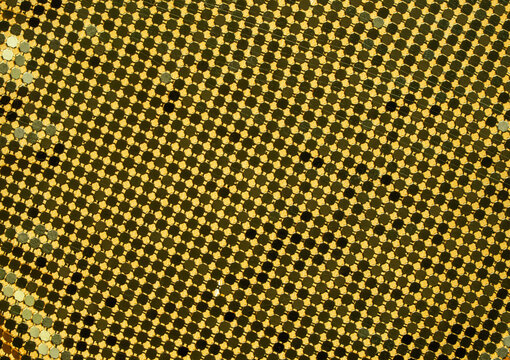 Gold sequins forming a shiny interconnected lattice pattern, creating a metallic background