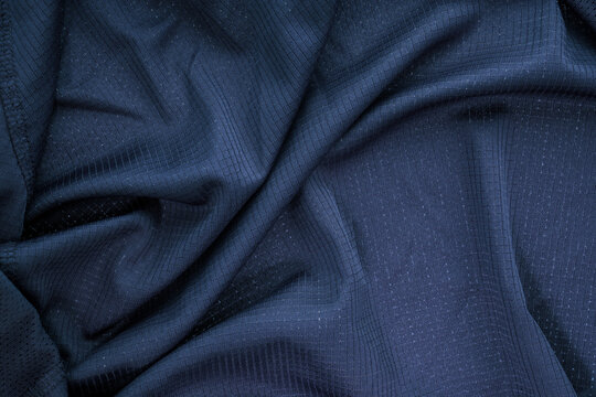 Dark blue sportswear fabric showing breathable texture and crumpled material