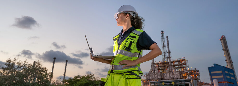 Inspector engineer inspecting petroleum engineering in oil refinery performance checklist inspection at fuel industrial plant Female petrol engineer hold laptop and checking at site during evening