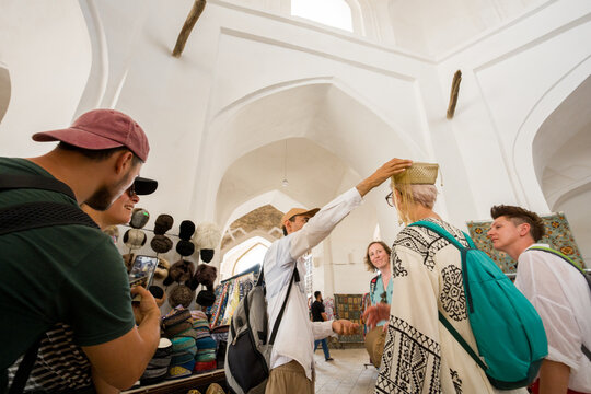 Tourists Try on Hats in a Local Market 