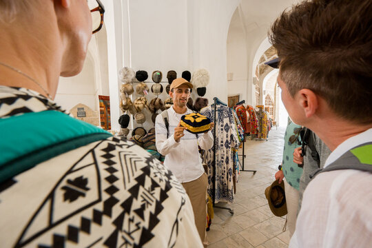 Tourists Learns About Local Hats in Uzbek Market 