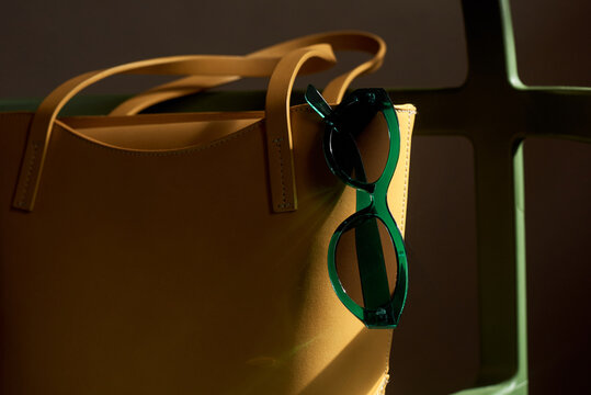 Close up of yellow bag with green sunglasses