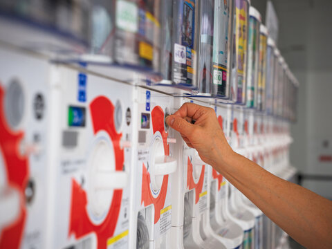 Person Using a Vending Gachapon Machine for Capsule Toys