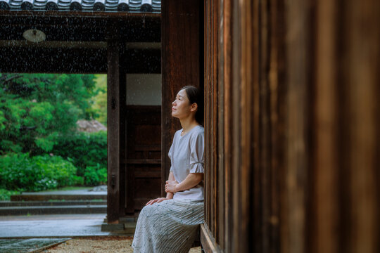 Woman Sheltering from Rain under a Traditional Japanese Engawa.