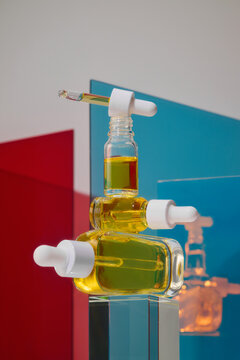 Stacked glass dropper bottles with golden serum