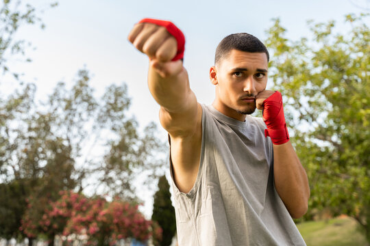 Boxer Practices Punches in Park During Sunny Afternoon