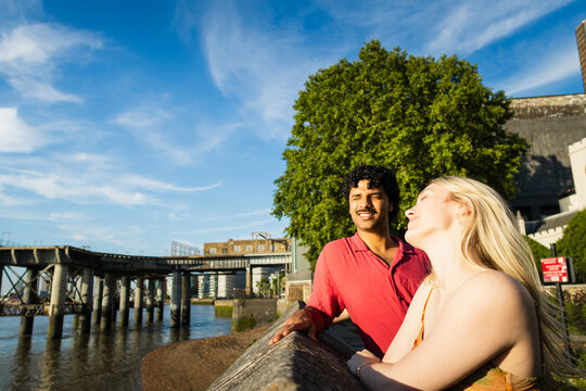 Young couple relaxing by the river bank on a sunny day