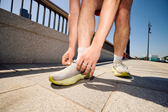 Man Ties Shoelaces While Preparing for a Run