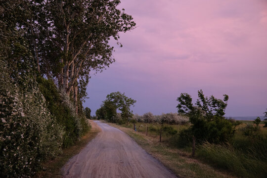 Empty Gravel Road at Pink Evening Sky