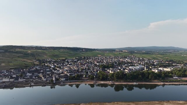 Drone aerial panorama of R&uuml;desheim am Rhein, Germany, featuring the historic riverside town, vineyards and the Rhine River under a clear summer sky. Scenic view of the famous wine region in the UNESCO