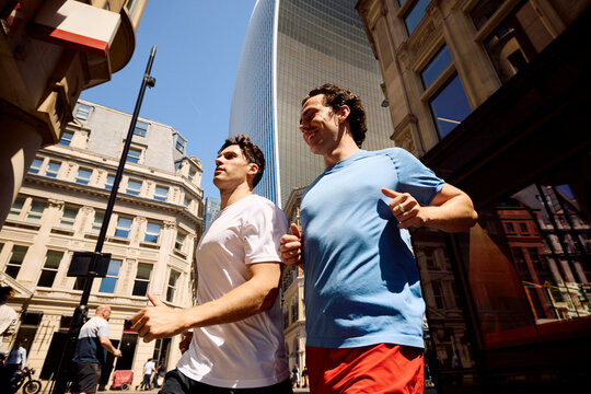 Men jog side by side in downtown London