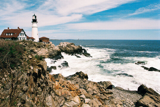View of Maine's Portland Head Light lighthouse on and rocky shore