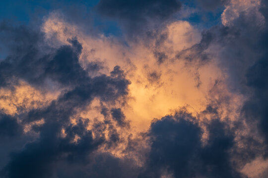 Cloudscape with dark and dramatic clouds at sunset in summer