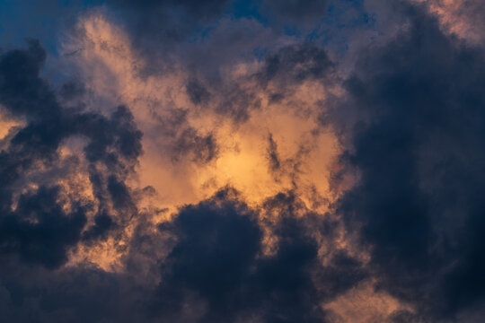 Cloudscape with dark and dramatic clouds at sunset in summer