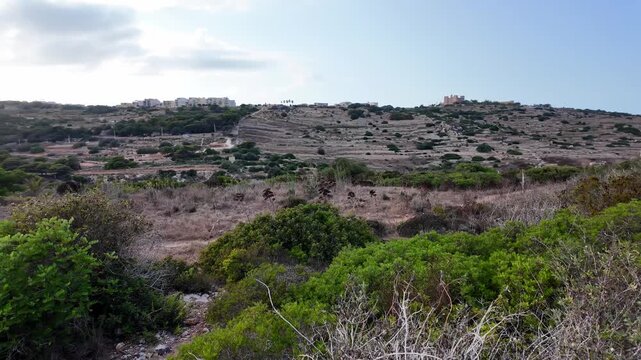 Surrounding area near Ancient Cart Ruts on Xemxija heritage trail, parallel cartways groves cut into bare rock.