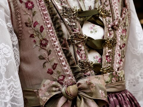 Detailaufnahme eines kunstvoll bestickten Dirndls &ndash; Florale Muster, Miederschn&uuml;rung, Metallhaken und Schleife zeigen hochwertiges Handwerk und elegante bayerische Tradition.