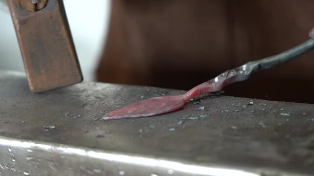 A Blacksmith's Craft: The Transformation of Hot Metal as a Skilled Artisan Shapes a Beautiful Design on the Anvil with Hammer Strikes