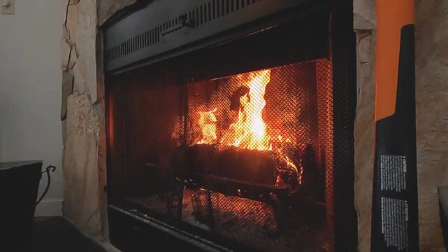 Warm Cozy Fireplace with Burning Firewood and Glowing Flames in Rustic Stone Hearth During Winter. Perfect for winter, home comfort, holiday, Christmas, and cozy living room background videos