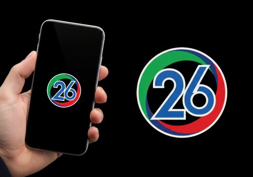 Hand holding a smartphone displaying the number 26 logo next to the logo on a black background