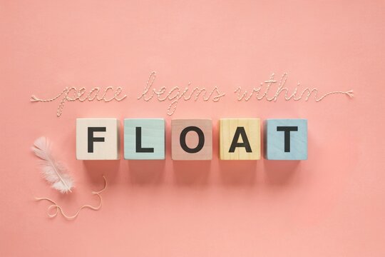 Pastel Wooden Blocks Spelling Float With Peace Begins Within Handwritten Script On Soft Pink Background