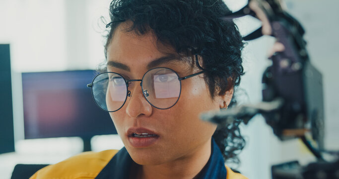 Close-up young Black female engineer coding AI robot arm in modern laboratory. Robotics, artificial intelligence, technology, stem, future, innovation, diversity, automation, machine learning concept.