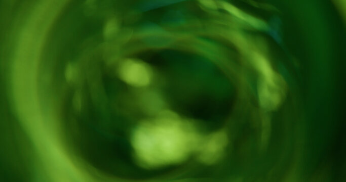 Bokeh light. Green glitter texture. Vibrant natural color lens flare bright optical glisten reflection on abstract illuminated black background.